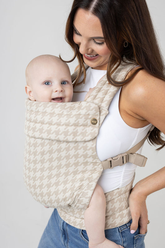 Parent wearing a baby in the Mabē Monarch carrier in Houndstooth