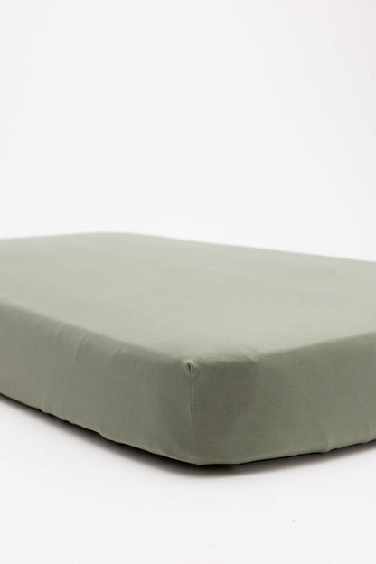 Green fitted Crib sheet on a bed against a white background for sale