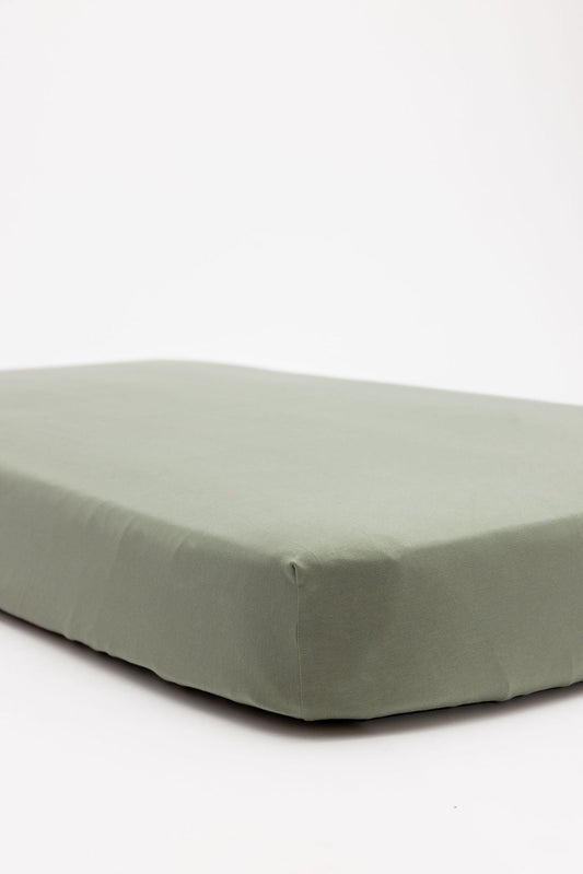 Green fitted Crib sheet on a bed against a white background for sale