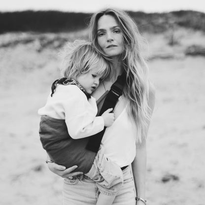 Mom holding son in Wildride Toddler Carrier Coffee in 100% cotton, a toddler hip carrier for babywearing