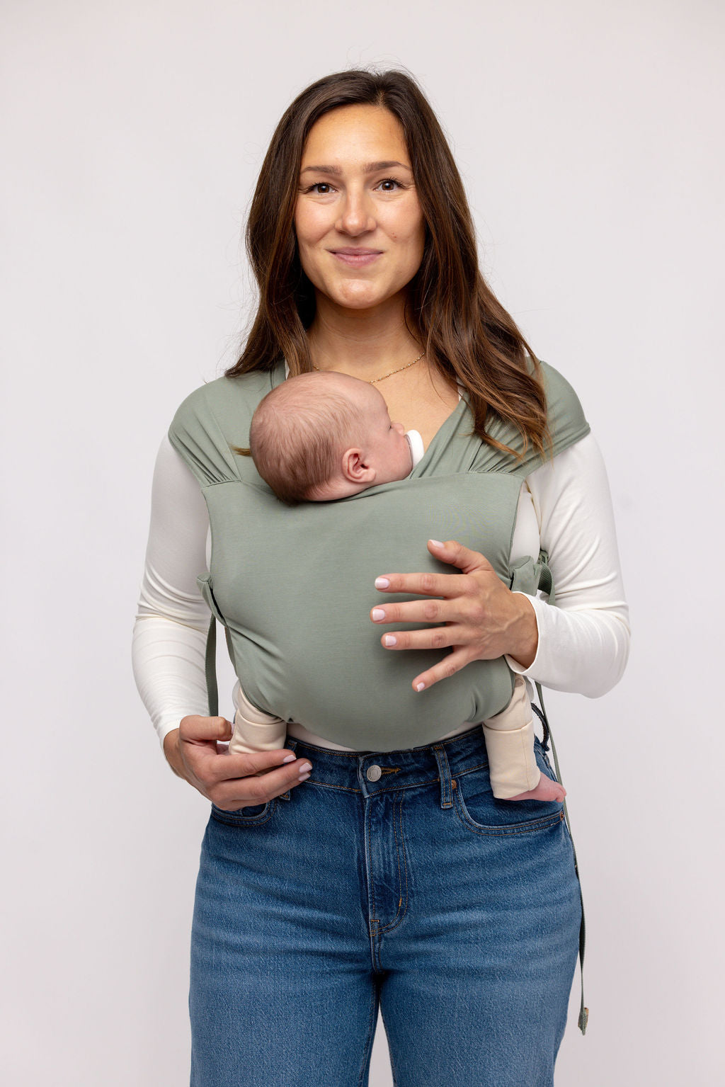 Mom wearing WildBird Aerial Newborn Buckle Wrap with newborn front carry facing in