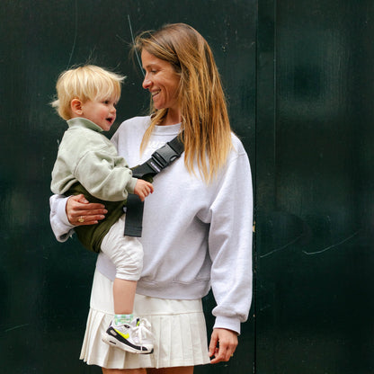 Mom holding todder in WildRide Army green carrier