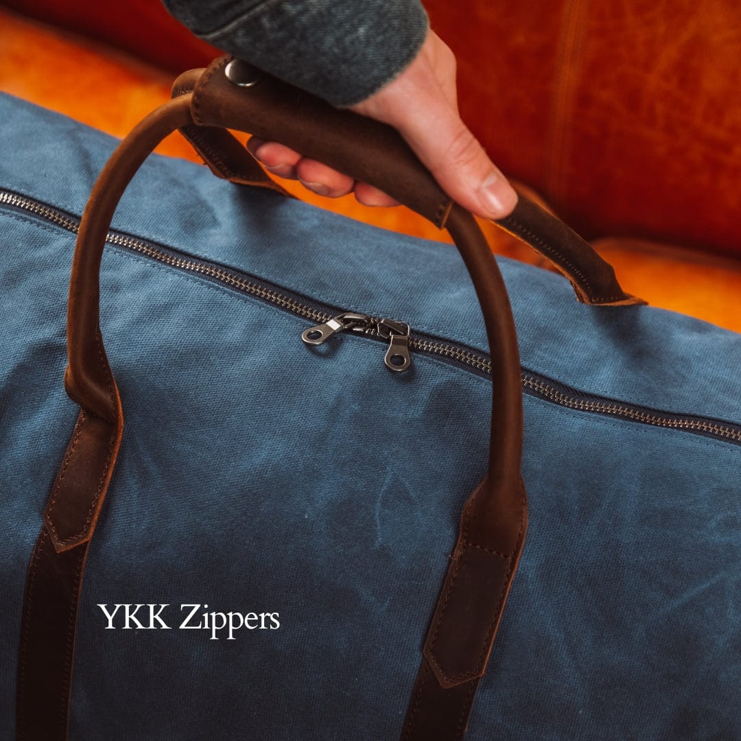 Blue bag with brown leather handles and YKK Zippers branding.